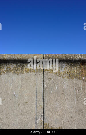 Zwei Betonfertigteile mit Ausdehnungsfugen und Algenwachstum sind Teil der Ufermauer, mit klarem blauen Himmel und ohne Wolken in Rossall lancashire uk Stockfoto