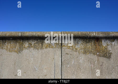 Zwei Betonfertigteile mit Ausdehnungsfugen und Algenwachstum sind Teil der Ufermauer, mit klarem blauen Himmel und ohne Wolken in Rossall lancashire uk Stockfoto