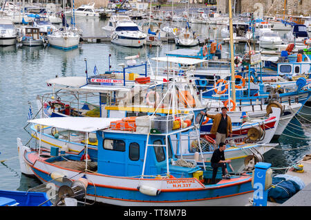 Heraklion, Kreta/Griechenland. Bunte traditionelle Fischerboote am alten venezianischen Hafen von Heraklion Stadt. Die Fischer auf ihren Booten Stockfoto