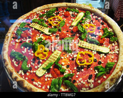 PIZZA belegt mit Basilikum, Paprika, Oliven, Käse, Tomaten, ZUCCINI, IN EINEM RESTAURANT IN VENEDIG, ITALIEN, angezeigt. Stockfoto