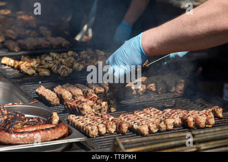 Shish Kebab mit den Gewürzen im Freien auf einem Holzkohlegrill. Frikadellen auf einem Grill. Stockfoto