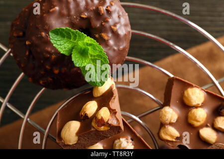Schokolade mit Nüssen und Minze auf Metallständer, Nahaufnahme Stockfoto