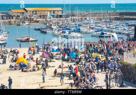 Lyme Regis, Dorset, Großbritannien. 15. Juni 2019. UK Wetter: Massen von Musiker und Besucher strömen zum Strand genießen Sie einen Nachmittag mit Musik als die jährliche Gitarren am Strand Veranstaltung erhält unterwegs am Strand in Lyme Regis an einem herrlichen Nachmittag im warmen Sonnenschein und strahlend blauen Himmel. Die Masse ist der Star der Show als Gitarristen aller Altersgruppen und Fähigkeiten zusammen am Strand versammeln sich als "größten der britischen Band' durchführen. Die Menschen genießen die entspannte Atmosphäre des Festivals, bevor Sie in diesem Jahr gewählten Song "am Strand" durchführen. Credit: Celia McMahon/Alamy Leben Nachrichten. Stockfoto