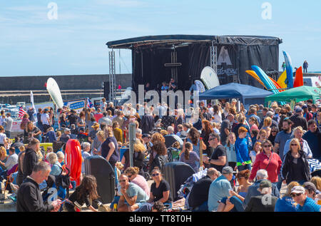 Lyme Regis, Dorset, Großbritannien. 15. Juni 2019. UK Wetter: Massen von Musiker und Besucher strömen zum Strand genießen Sie einen Nachmittag mit Musik als die jährliche Gitarren am Strand Veranstaltung erhält unterwegs am Strand in Lyme Regis an einem herrlichen Nachmittag im warmen Sonnenschein und strahlend blauen Himmel. Die Masse ist der Star der Show als Gitarristen aller Altersgruppen und Fähigkeiten zusammen am Strand versammeln sich als "größten der britischen Band' durchführen. Die Menschen genießen die entspannte Atmosphäre des Festivals, bevor Sie in diesem Jahr gewählten Song "am Strand" durchführen. Credit: Celia McMahon/Alamy Leben Nachrichten. Stockfoto