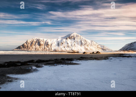 Landschaft von Sonnenlicht auf verschneiten Gebirge auf der Küstenlinie bei Skagsanden Strand Stockfoto