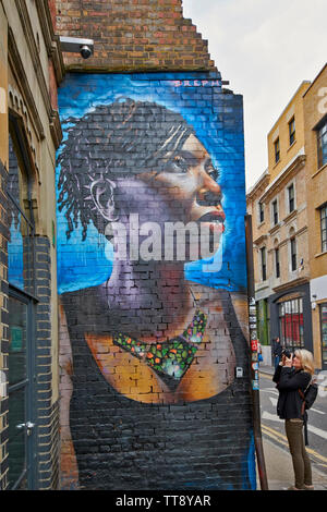 LONDON ENGLAND BRICK LANE PERSON FOTOGRAFIEREN WANDMALEREIEN oder Graffiti Stockfoto