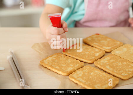 Kleines Mädchen Dekoration vorbereitet Cookies in der Küche zu Hause. Stockfoto