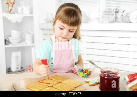 Kleines Mädchen Dekoration vorbereitet Cookies in der Küche zu Hause. Stockfoto