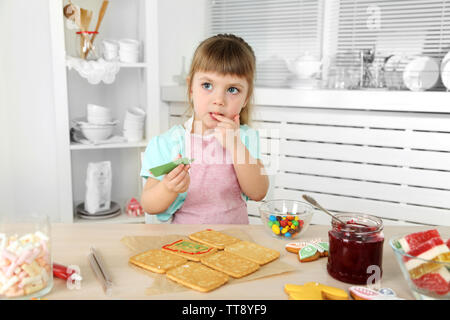 Kleines Mädchen Dekoration vorbereitet Cookies in der Küche zu Hause. Stockfoto