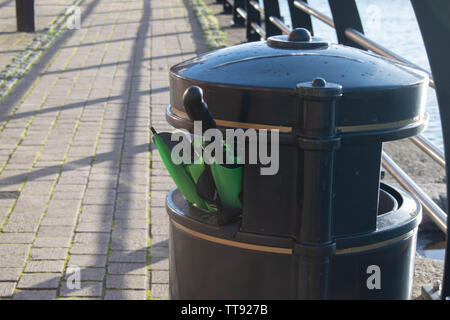 Grüne und schwarze Golf Regenschirm in einem Fach nach windigen Wetter in Swansea, Wales, UK geworfen. Stockfoto