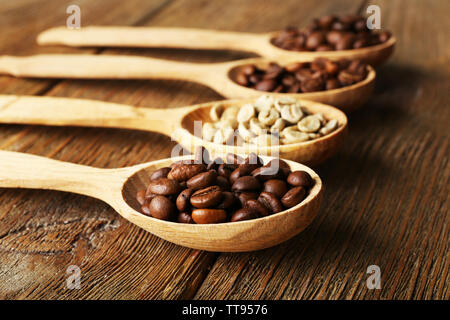 Kaffeebohnen in Löffel auf Holz- Hintergrund Stockfoto