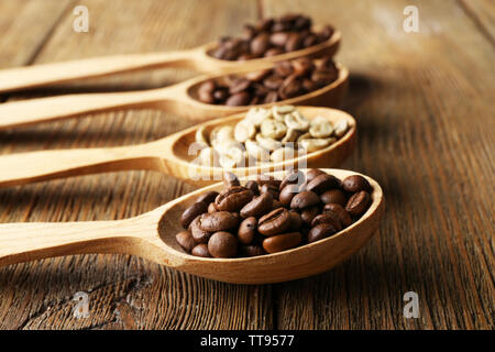 Kaffeebohnen in Löffel auf Holz- Hintergrund Stockfoto