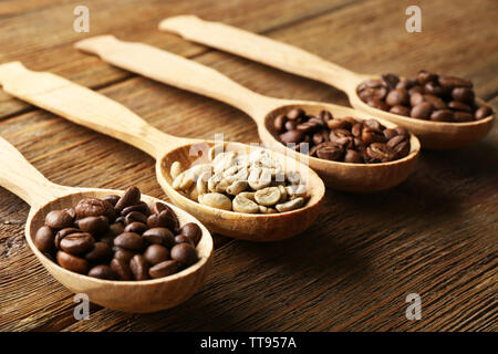 Kaffeebohnen in Löffel auf Holz- Hintergrund Stockfoto