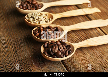 Kaffeebohnen in Löffel auf Holz- Hintergrund Stockfoto