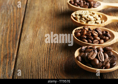 Kaffeebohnen in Löffel auf Holz- Hintergrund Stockfoto