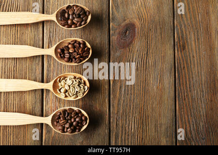 Kaffeebohnen in Löffel auf Holz- Hintergrund Stockfoto