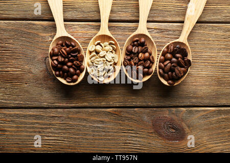 Kaffeebohnen in Löffel auf Holz- Hintergrund Stockfoto