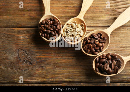 Kaffeebohnen in Löffel auf Holz- Hintergrund Stockfoto