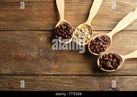 Kaffeebohnen in Löffel auf Holz- Hintergrund Stockfoto