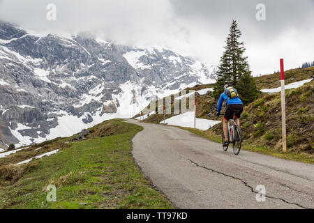 An der Spitze der Grosse Scheidegg pass auf der östlichen Seite von Meiringen, eine männliche Radfahrer gegen die drastischen Schweizer Bergwelt gezeigt Stockfoto