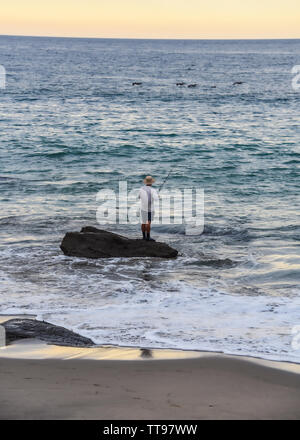 Mancora, Peru - 18. April 2019: ein Fischer bei Sonnenuntergang am Strand Playa las Pocitas Stockfoto