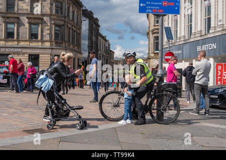 Paisley, Schottland, Großbritannien. 15 Juni, 2019. Ein Junge bekommt sein Foto mit einem Offizier von der Polizei Schottland auf einem Fahrrad an Paisley Carfest 2019 In diesem Jahr feiert er den 6. Jahrestag. Gezeigt werden eine Reihe von klassischen Fahrzeugen, Oldtimer, Spezialist kundenspezifische Autos, Muscle Cars, supercars und Einsatzfahrzeuge. Alle Spendengelder gehen an dem Tag, an dem St. Vincent's Hospiz in Howwood zu unterstützen. Credit: Skully/Alamy leben Nachrichten Stockfoto