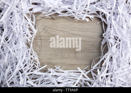 Rahmen der Papierstreifen von Shredder auf Holztisch, Nahaufnahme Stockfoto