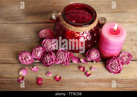 Spa Stillleben mit Kerze und getrocknete Rosen auf hölzernen Hintergrund Stockfoto