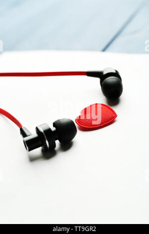 Kopfhörer auf weißem Blatt Papier mit kleinen Herzen, Nahaufnahme Stockfoto