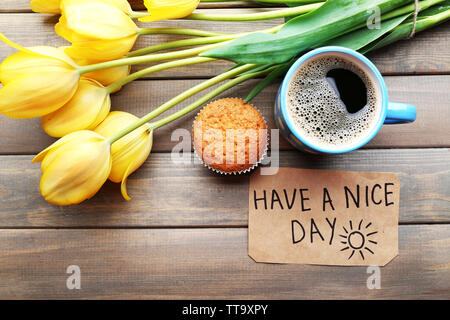 Tasse Kaffee mit frischen Kuchen, Tulpen und haben einen schönen Tag Massage auf Holz- Hintergrund Stockfoto