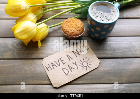 Tasse Kaffee mit frischen Kuchen, Tulpen und haben einen schönen Tag Massage auf Holz- Hintergrund Stockfoto