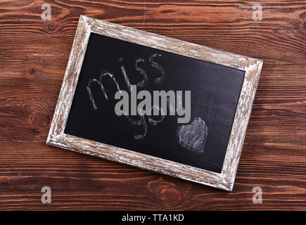 Inschrift verpassen Sie auf Tafel auf hölzernen Hintergrund Stockfoto