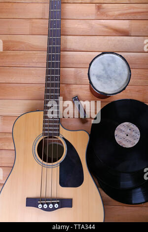 Gitarre mit Schallplatten und afrikanische Trommel auf holztisch Nahaufnahme Stockfoto