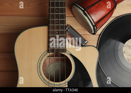 Gitarre mit Schallplatten und afrikanische Trommel auf holztisch Nahaufnahme Stockfoto