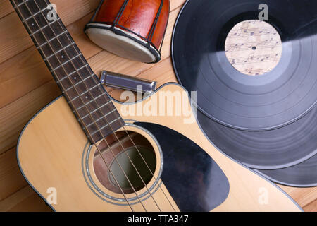 Gitarre mit Schallplatten und afrikanische Trommel auf holztisch Nahaufnahme Stockfoto