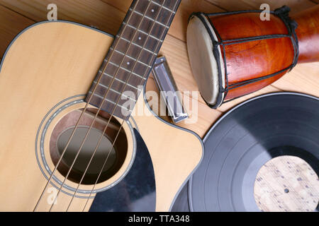 Gitarre mit Schallplatten und afrikanische Trommel auf holztisch Nahaufnahme Stockfoto