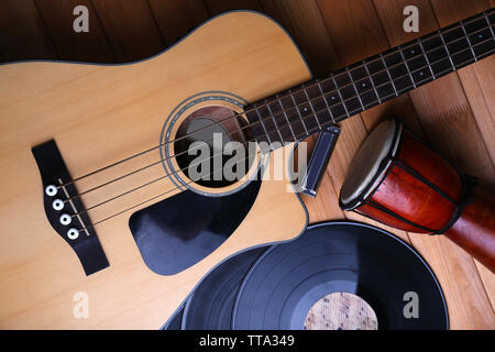 Gitarre mit Schallplatten und afrikanische Trommel auf holztisch Nahaufnahme Stockfoto