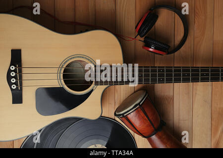 Gitarre mit Schallplatten und afrikanische Trommel auf holztisch Nahaufnahme Stockfoto