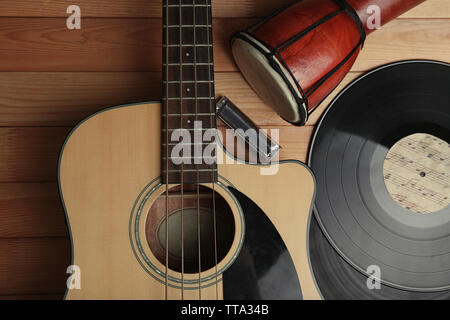 Gitarre mit Schallplatten und afrikanische Trommel auf holztisch Nahaufnahme Stockfoto