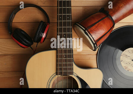 Gitarre mit Schallplatten und afrikanische Trommel auf holztisch Nahaufnahme Stockfoto