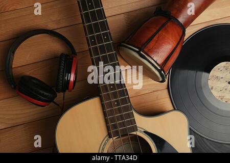 Gitarre mit Schallplatten und afrikanische Trommel auf holztisch Nahaufnahme Stockfoto