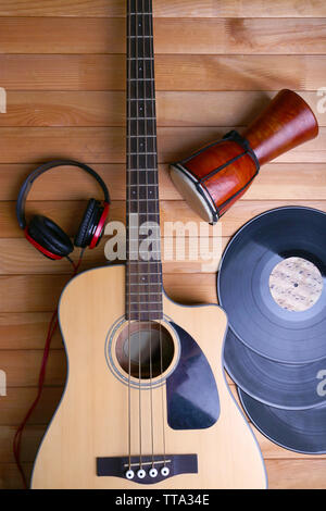 Gitarre mit Schallplatten und afrikanische Trommel auf holztisch Nahaufnahme Stockfoto