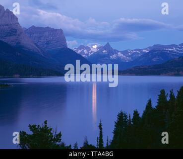 USA, Montana, Glacier National Park; Full moon Sets in der Morgendämmerung über Knallen Berg und St. Mary Lake. Stockfoto