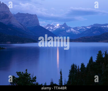 USA, Montana, Glacier National Park; Full moon Sets in der Morgendämmerung über Knallen Berg und St. Mary Lake. Stockfoto