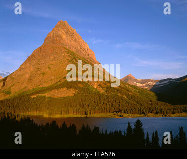 USA, Montana, Glacier National Park, Sunrise Licht auf Grinnell Punkt über swiftcurrent Lake. Stockfoto