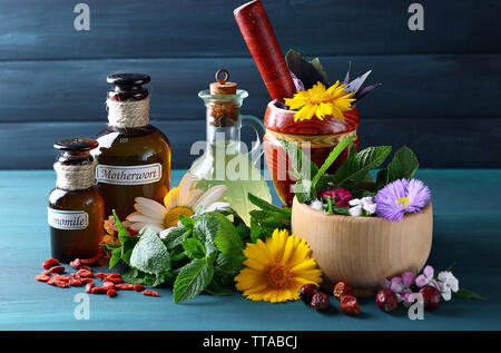 Kräuter, Beeren, Blumen und Pillen auf Farbe holztisch Hintergrund Stockfoto