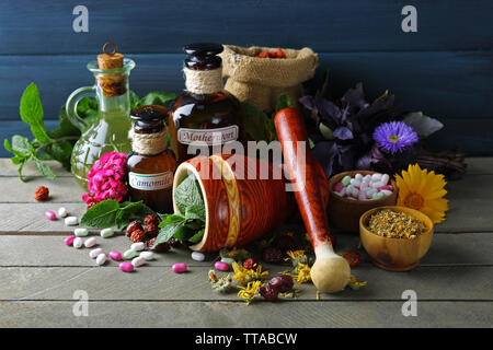 Kräuter, Beeren, Blumen und Pillen auf Farbe holztisch Hintergrund Stockfoto