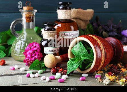 Kräuter, Beeren, Blumen und Pillen auf Farbe holztisch Hintergrund Stockfoto