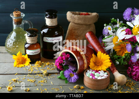 Kräuter, Beeren, Blumen und Pillen auf Farbe holztisch Hintergrund Stockfoto