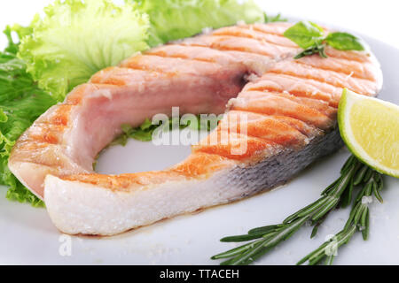 Lecker gegrillter Lachs mit Limette und Grüns auf Platte Nahaufnahme Stockfoto